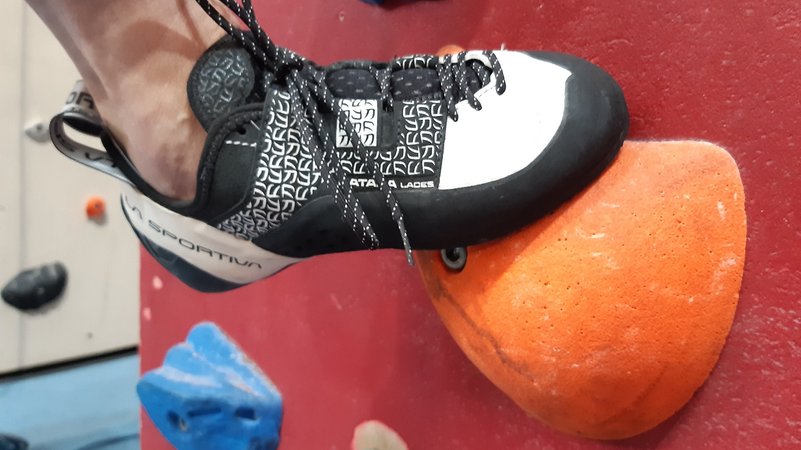 Schwarzweißer Kletterschuh einer Sportlerin, die in der Kletterhalle Weilheim auf einem organgefarbenen Tritt steht | Bild: BR/Angela Braun Schwarzweißer Kletterschuh einer Sportlerin, die in der Kletterhalle Weilheim auf einem organgefarbenen Tritt steht