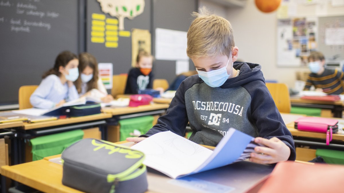 Kinder mit Atemschutzmasken im Unterricht