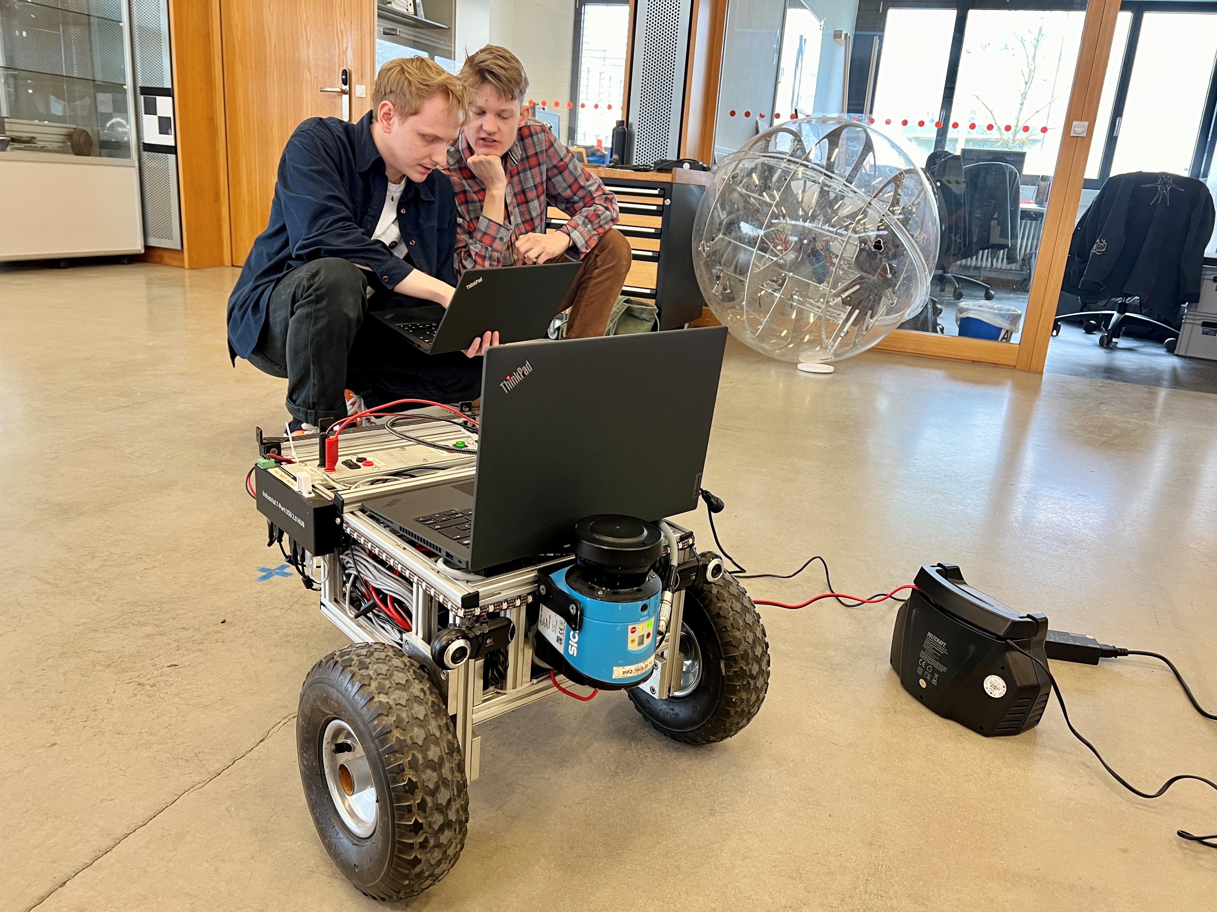 Julius Arzberger und Martin Hesse von der Universität Würzburg tüfteln am Mars-Roboter.