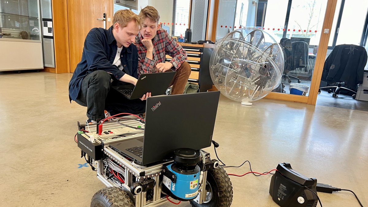 Julius Arzberger und Martin Hesse von der Universität Würzburg tüfteln am Mars-Roboter.