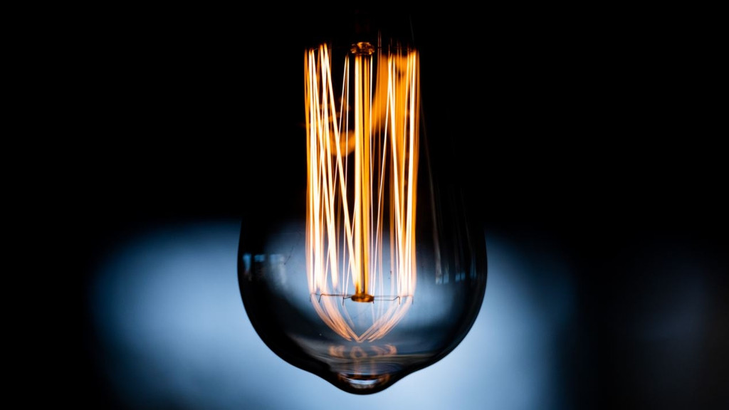Eine Lampe leuchtet schwach in einem Wohnzimmer (Symbolbild). 