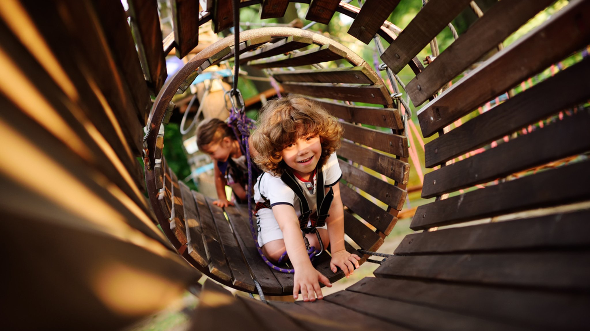 Kinder beim Spielen auf einem Abendteuerspielplatz 