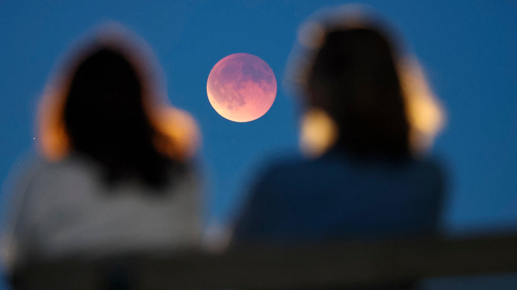 Zwei Frauen beobachten den Blutmond. | Bild: dpa-Bildfunk/Jan Woitas Zwei Frauen beobachten den Blutmond.
