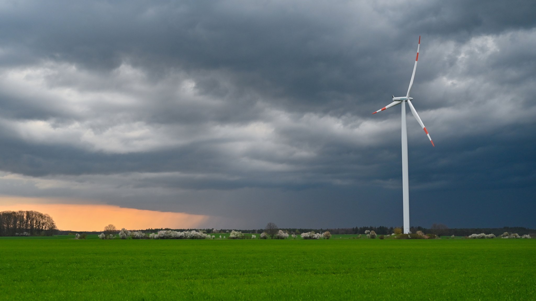 Dunkle Gewitterwolken ziehen über einem Windrad von Siemens auf.