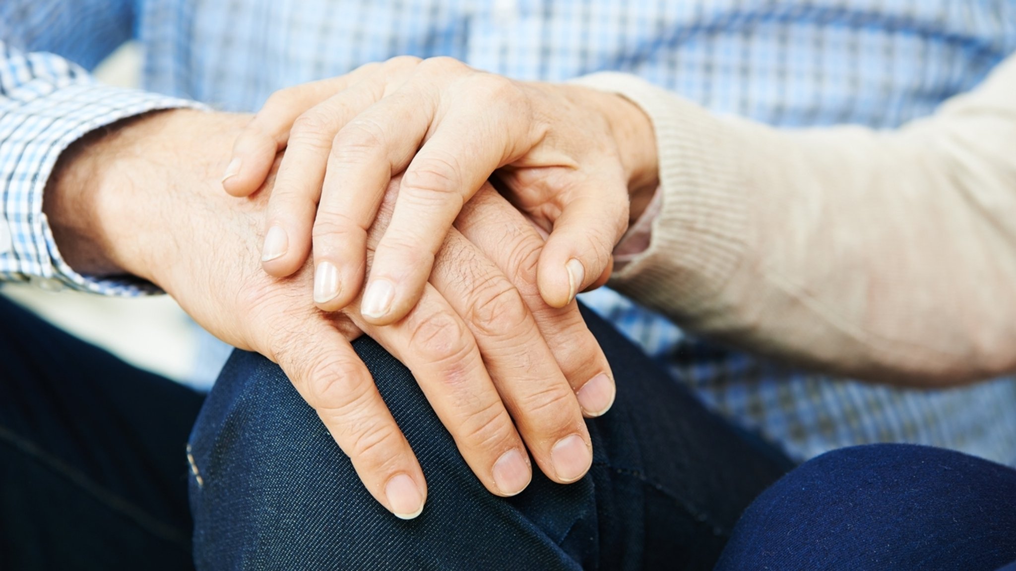 Die Hand einer Frau liegt auf der Hand eines Mannes (Symbolbild)