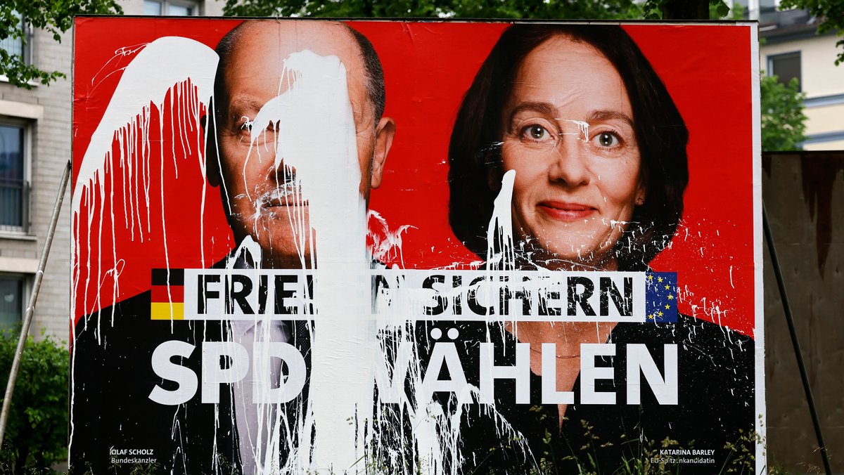 Ein SPD-Wahlplakat zur Europawahl 2024 mit den Portraits von Olaf Scholz und Katarina Barley. Die Aufschrift 'Frieden sichern - SPD wählen' wurde mit weißer Farbe verunstaltet.