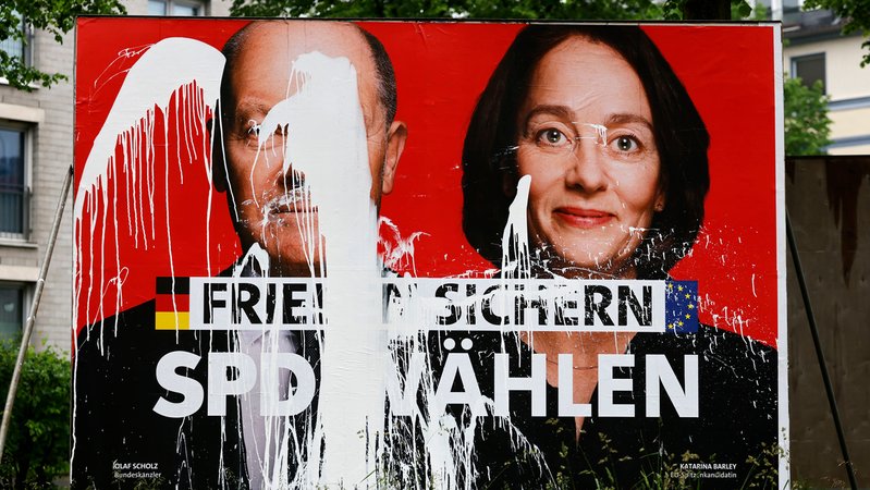 Ein SPD-Wahlplakat zur Europawahl 2024 mit den Portraits von Olaf Scholz und Katarina Barley. Die Aufschrift 'Frieden sichern - SPD wählen' wurde mit weißer Farbe verunstaltet. | Bild: picture alliance / Panama Pictures | Christoph Hardt Ein SPD-Wahlplakat zur Europawahl 2024 mit den Portraits von Olaf Scholz und Katarina Barley. Die Aufschrift 'Frieden sichern - SPD wählen' wurde mit weißer Farbe verunstaltet.