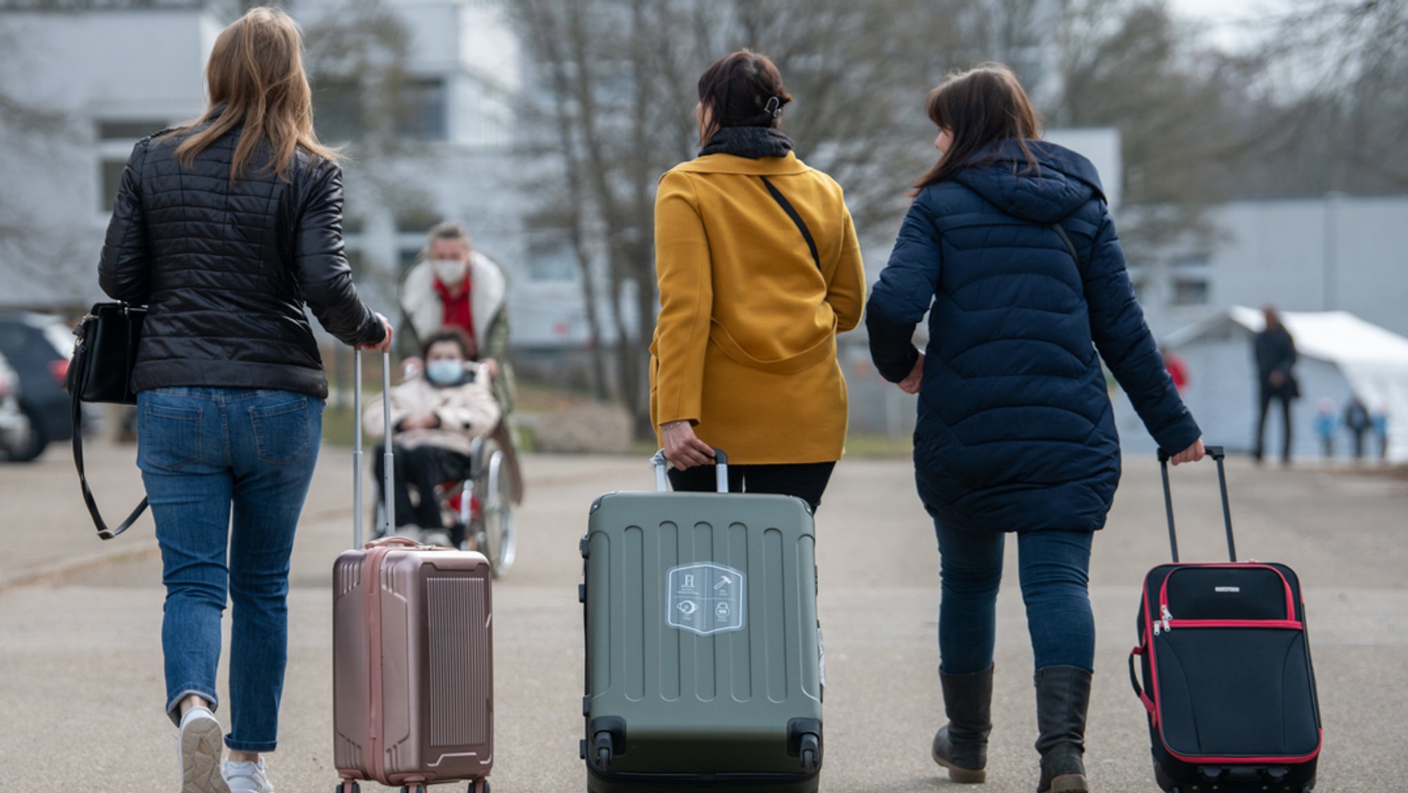 Drei aus der Ukraine stammende Frauen gehen in der Landeserstaufnahmestelle für Flüchtlinge (LEA) zu ihrem Quartier.