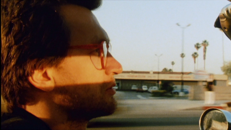 Ein Mann sitzt am Steuer eines Autos, das Licht der Sonne leuchtet seine Augen dramatisch aus: Szene aus Wim Wenders "Desperado"