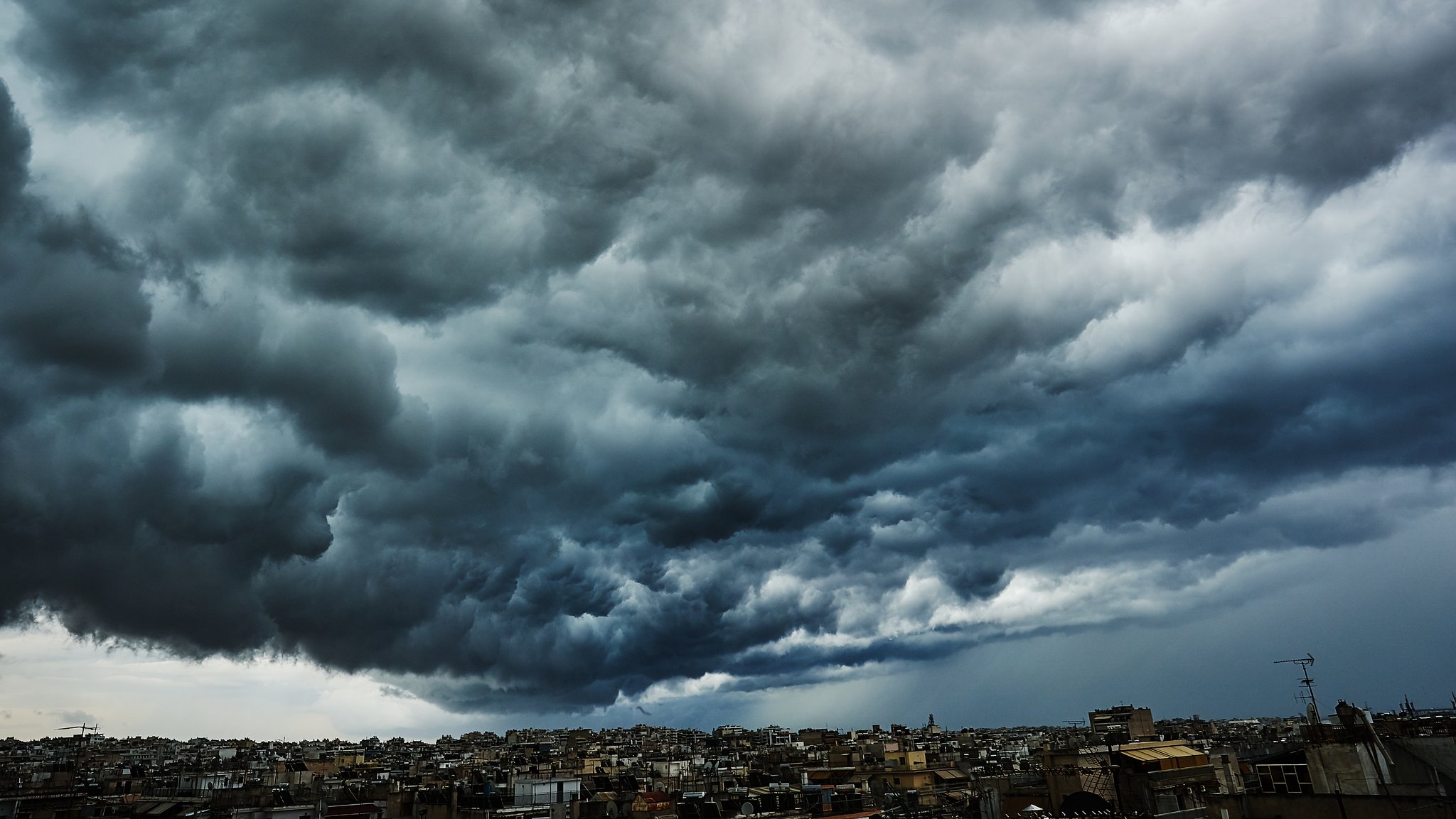 Dunkle Wolken ziehen über einer Stadt auf