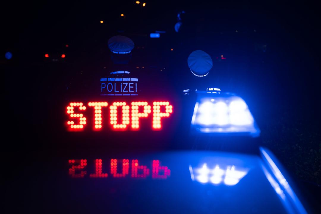 Polizeiauto mit blinkendem STOPP-Signal. 