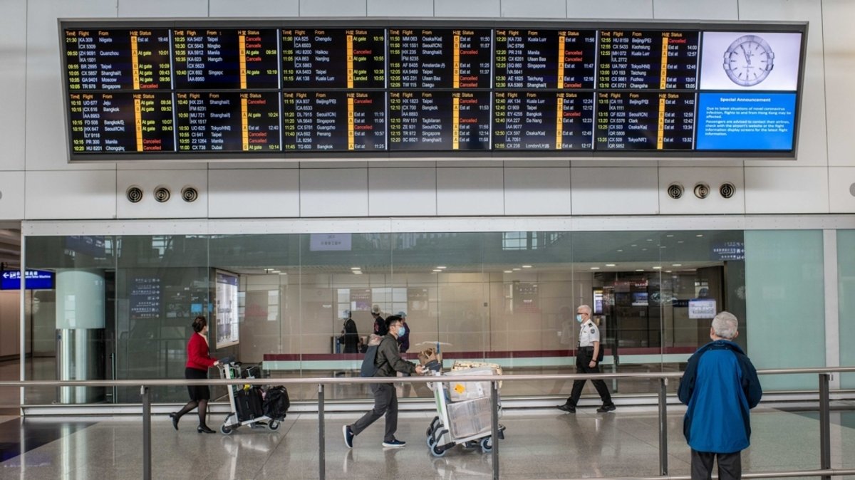 Reisende tragen Schutzmasken am Hong Kong international Flughafen.