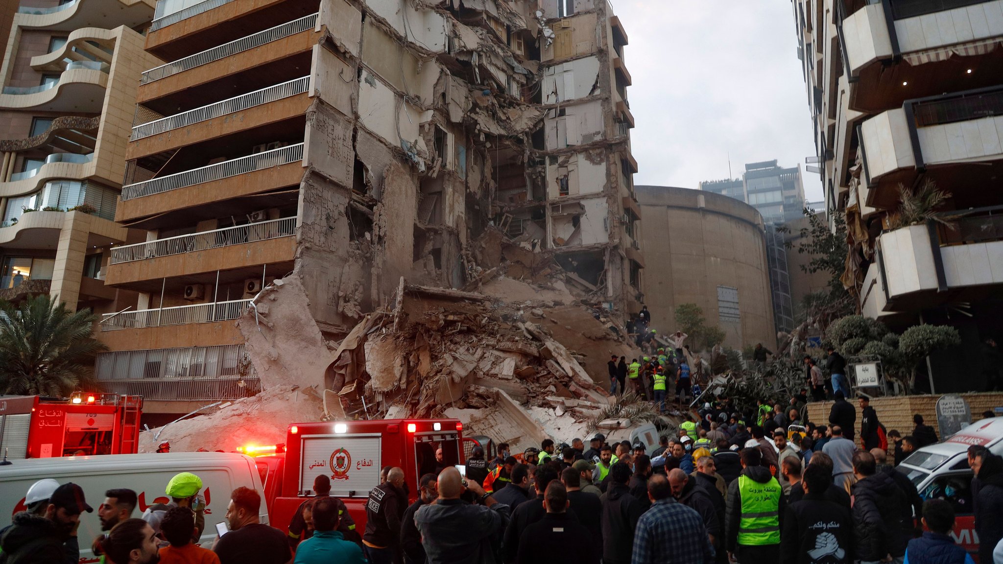 Israel greift weiter Ziele im Libanon an: Menschen versammeln sich vor einem zerstörten Wohnhaus in Beirut