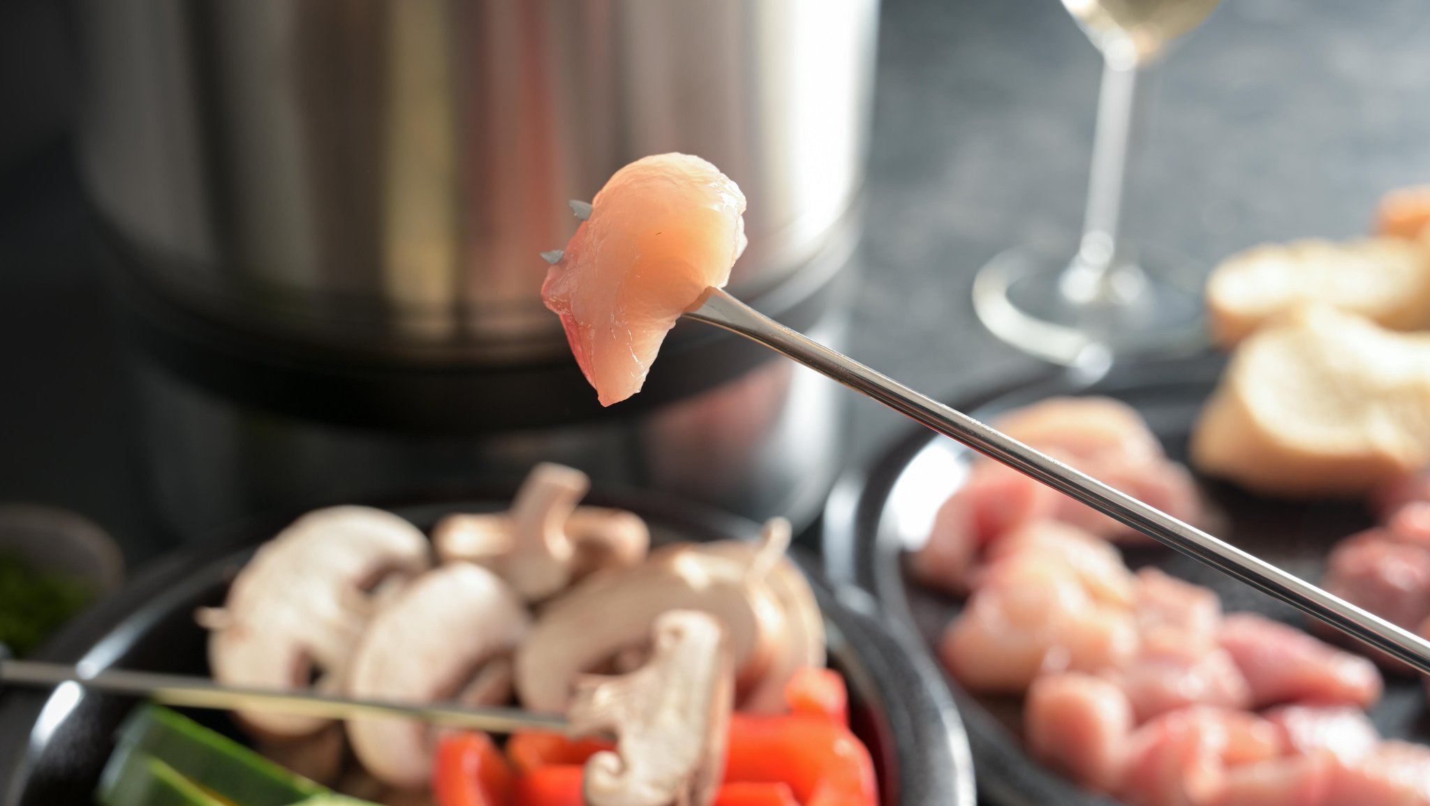 Ein Stück rohes Fleisch auf einem Fondue-Spieß