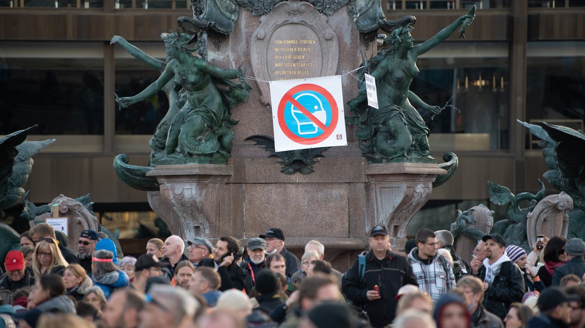 Teilnehmer der Demonstration der Stuttgarter Initiative „Querdenken“ stehen vor dem Mendebrunnen auf dem Augustusplatz. An der Kundgebung gegen die von Bund und Ländern beschlossenen Corona-Maßnahmen nahmen mehrere Tausend Menschen teil.