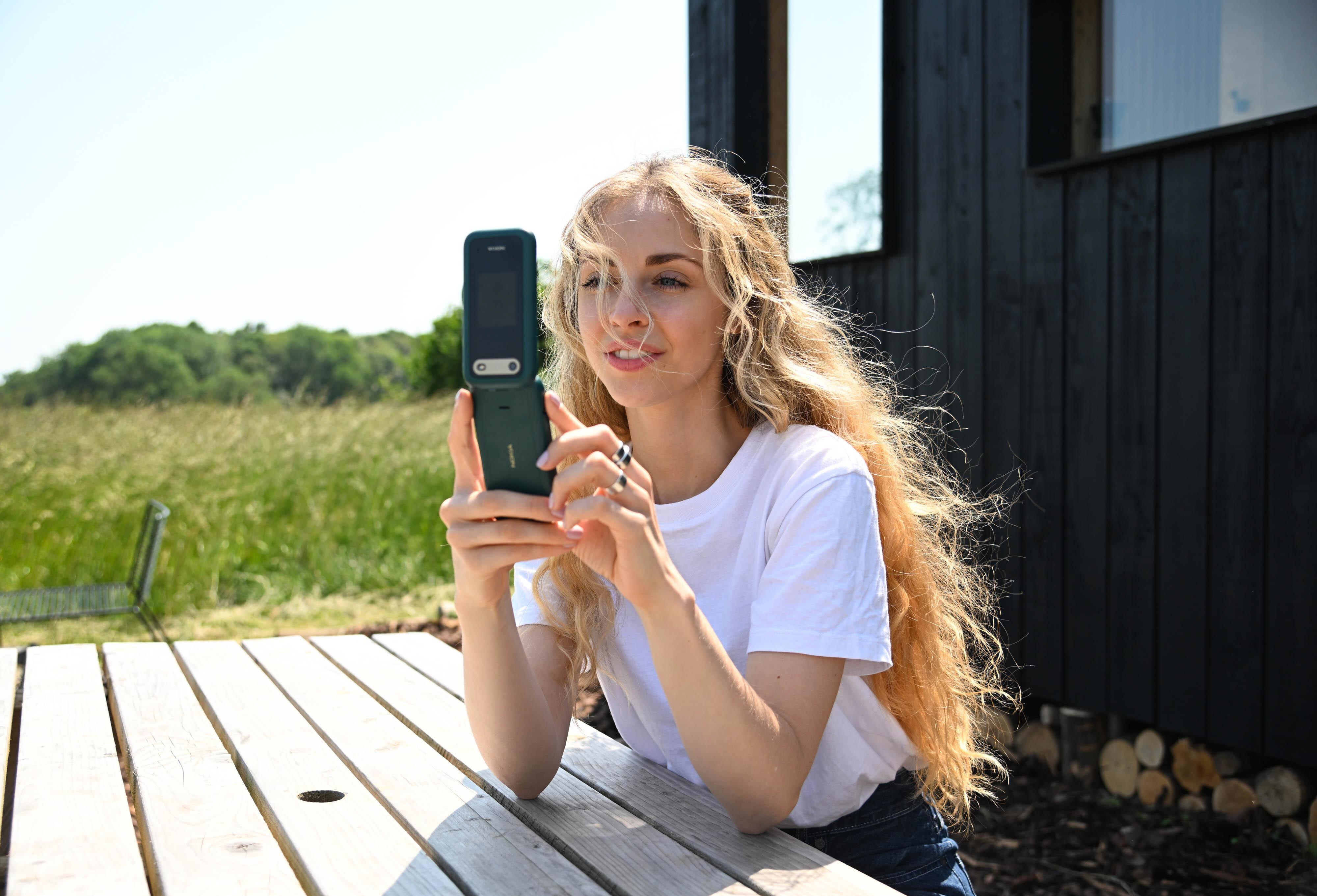 Eine Frau schaut auf ein Nokia-Klapphandy