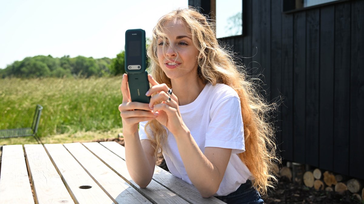 Eine Frau schaut auf ein Nokia-Klapphandy