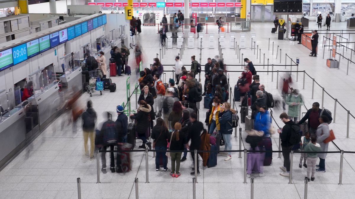Das Bild zeigt Reisende beim Check In am South Terminal des britischen Gatwick Airports in West Sussex.