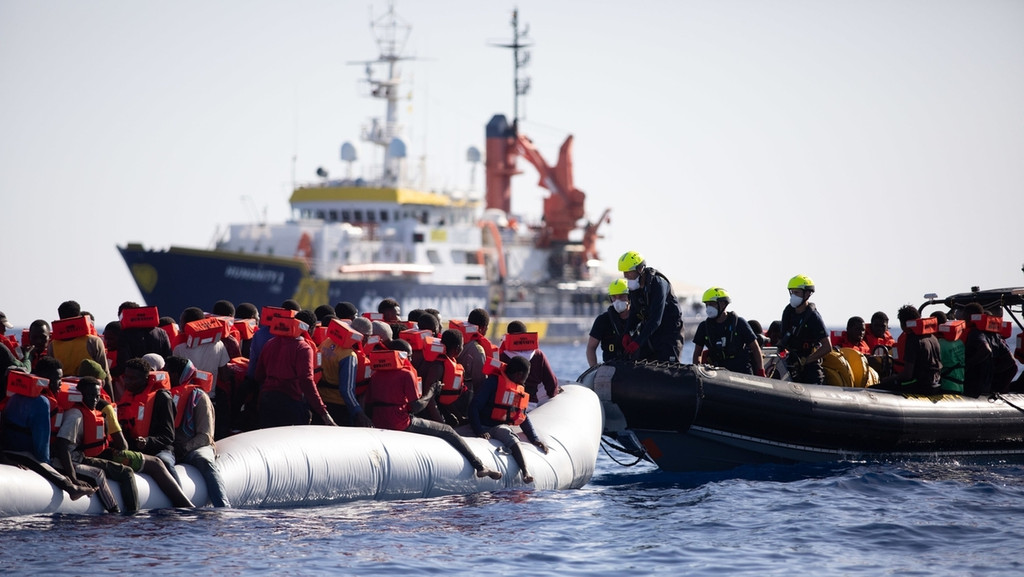 Ein überfülltes Schlauchboot mit geflüchteten Menschen wird auf dem Mittelmeer von der Crew eines privaten Seenotrettungsschiffes gerettet.