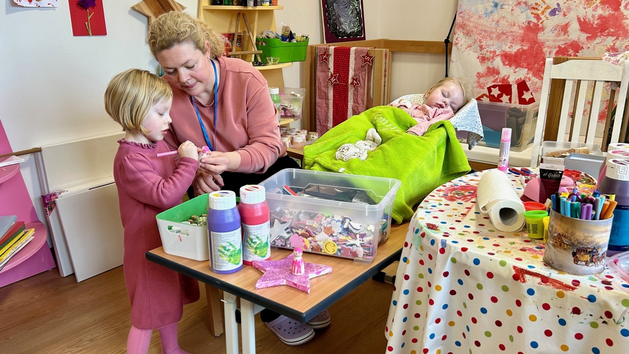 Eine erwachsene Frau und zwei Kinder in einem Kinderhospiz. 