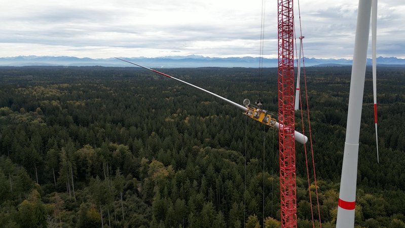 Das erste von sechs beschädigten Rotorblättern wird aus über 160 Meter Höhe abmontiert und mit einem Kran abgelassen.