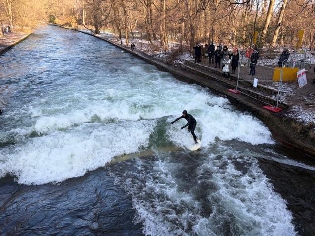 Ein Surfer surft auf der Münchner Eisbachwelle