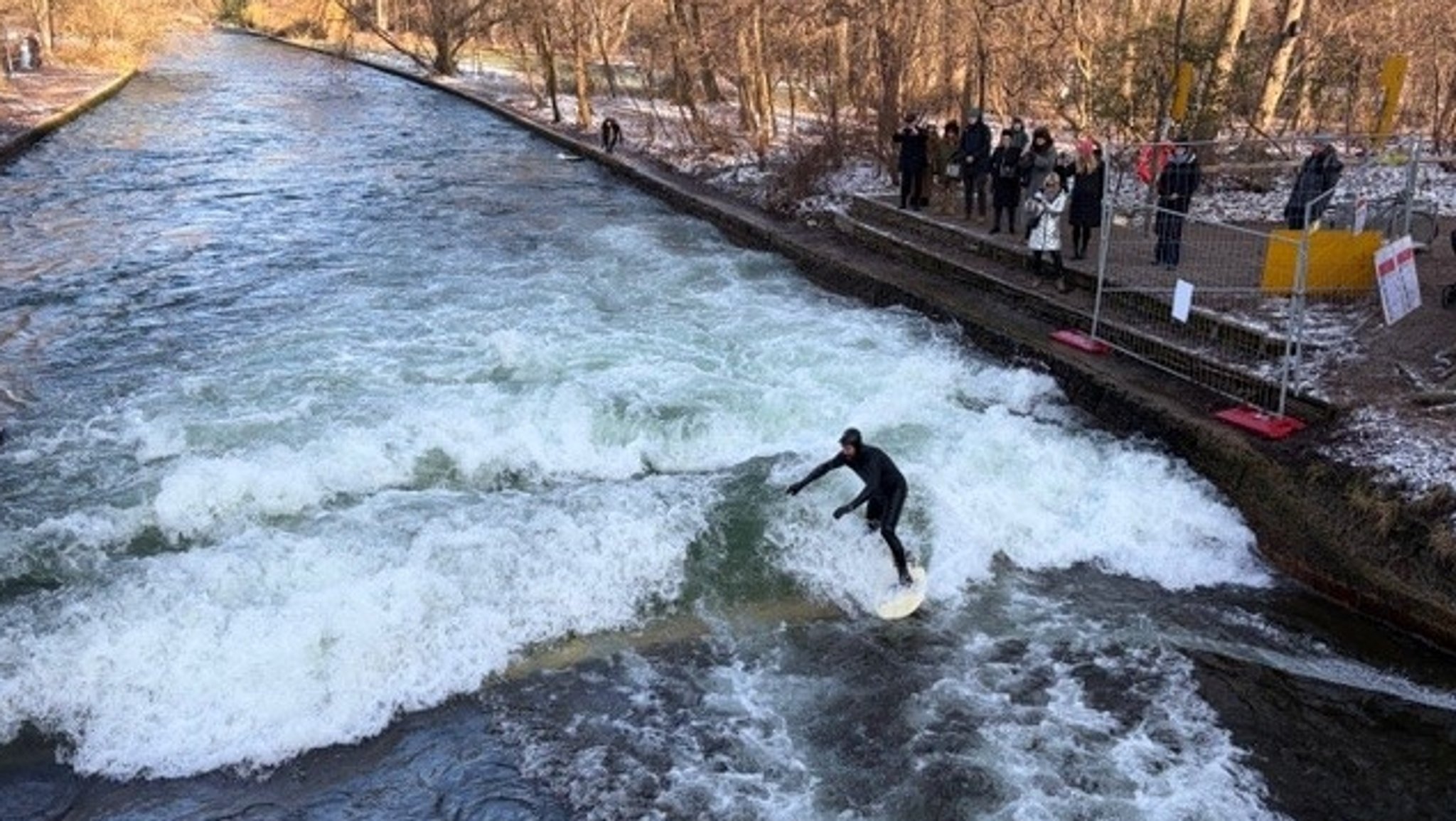 Ein Surfer surft auf der Münchner Eisbachwelle
