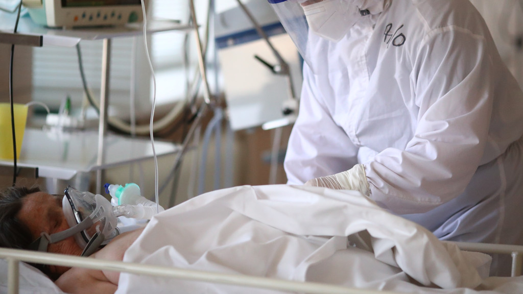 Person an Beatmungsmaschine angeschlossen, behandelt von einem Arzt in Krankenhaus; Zahlenanalyse zu Corona-Infektionen bei Geimpften