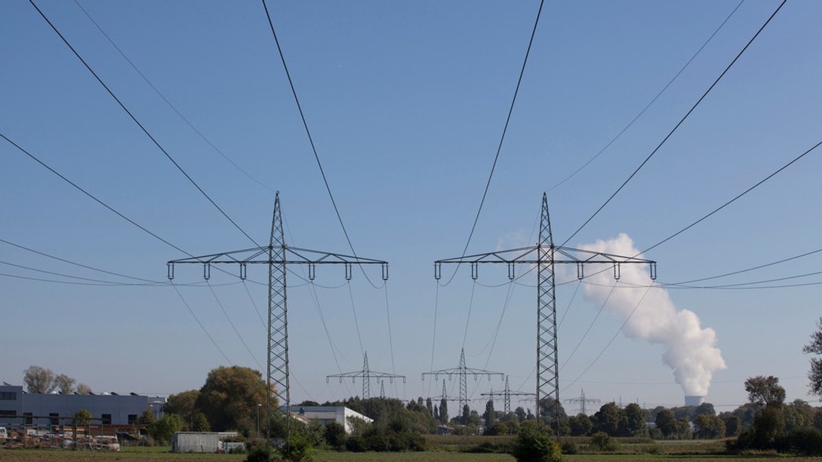 Strommasten in Bayern, im Hintergrund AKW Isar 2, das am 15.04.2023 vom Netz genommen wurde.