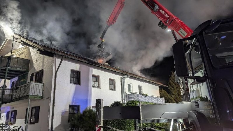 Ein Kran reißt an einem Mehrfamilienhaus in Neuhaus am Inn Photovoltaik-Paneele vom Dach, damit die Feuerwehr darunter löschen kann. | Bild: zema-medien Ein Kran reißt an einem Mehrfamilienhaus in Neuhaus am Inn Photovoltaik-Paneele vom Dach, damit die Feuerwehr darunter löschen kann.