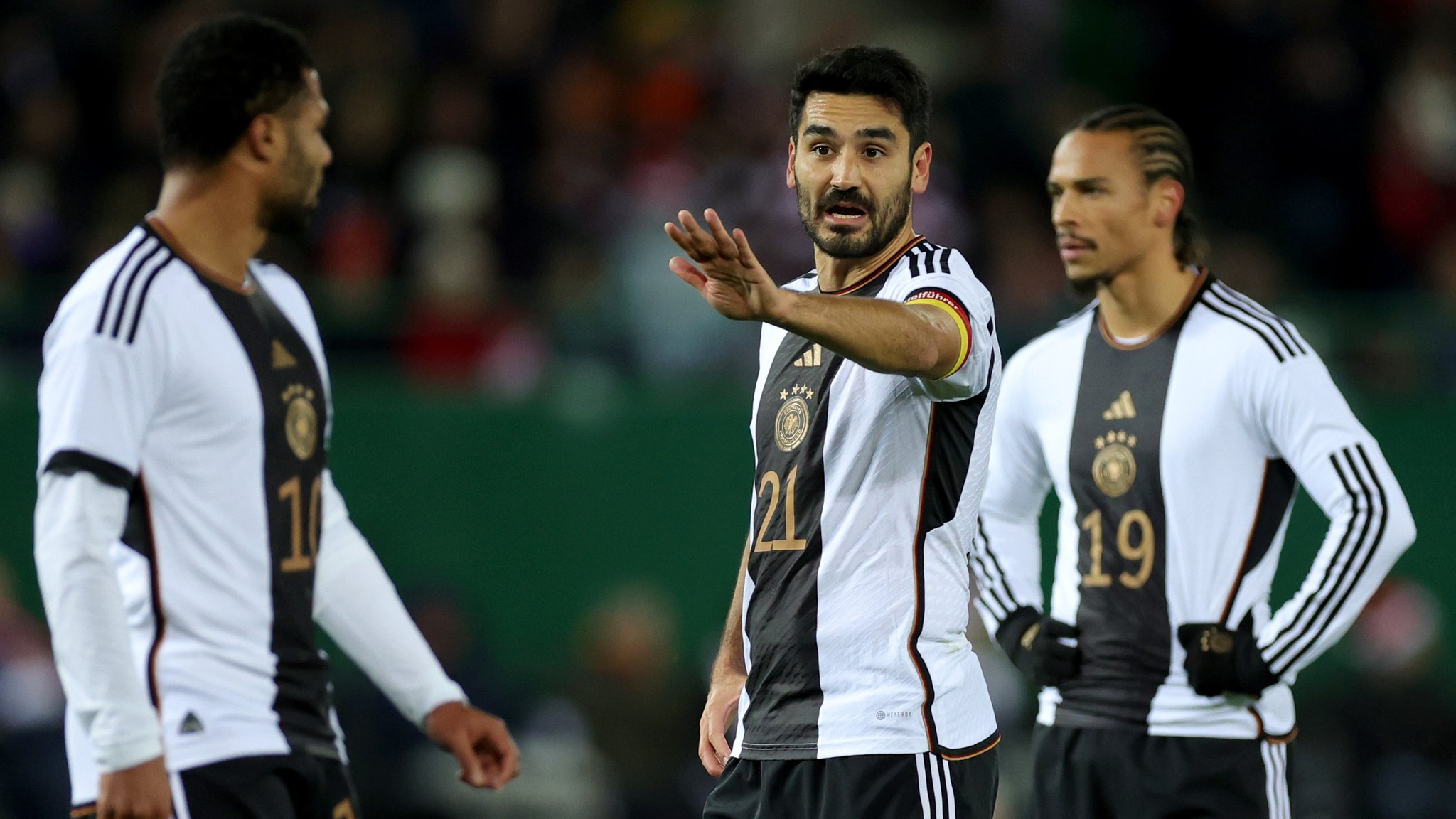 Deutschlands Ilkay Gündogan (2.vr) gibt neben Deutschlands Serge Gnabry (l) und Leroy Sane Anweisungen.