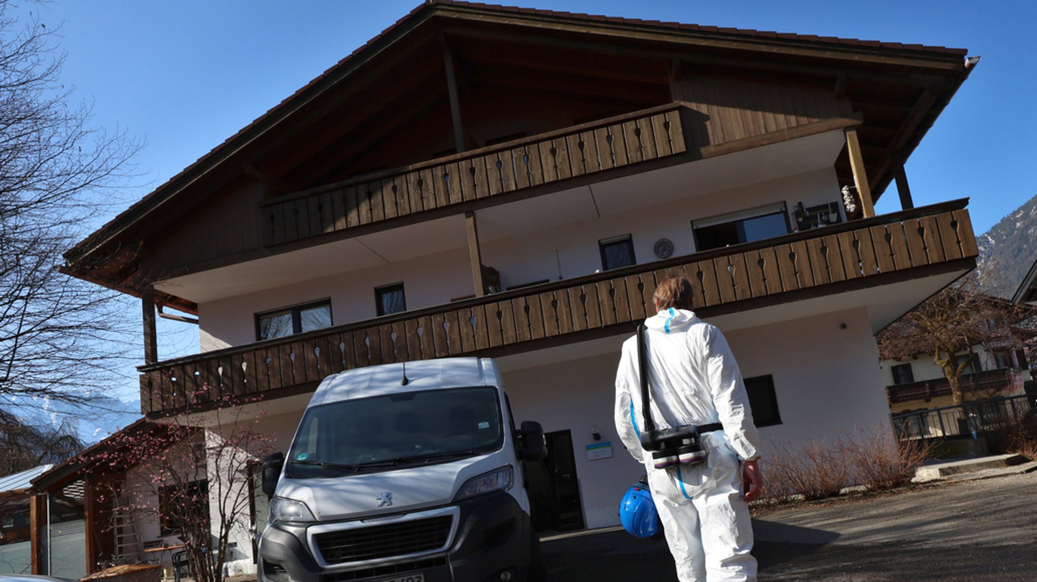 Ein Mitarbeiter der Spurensicherung der Polizei steht am 7.3.2025 vor einem Mehrfamilienhaus in der Innenstadt von Garmisch-Partenkirchen.