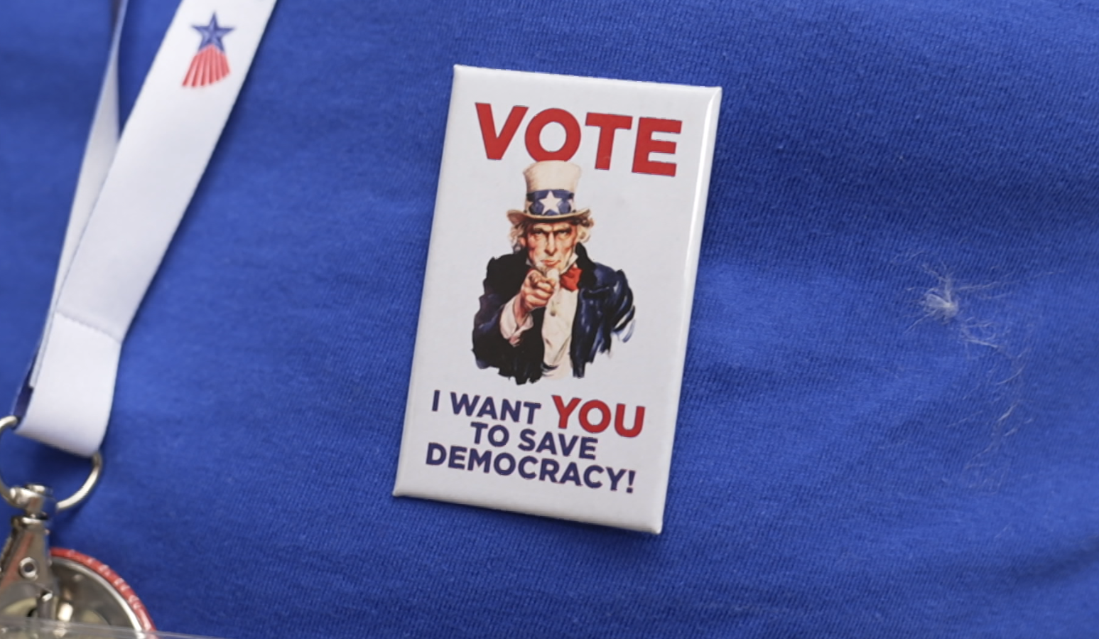 Zu sehen ist ein Sticker auf einem T-Shirt, der auf Englisch zur Wahl aufruft.