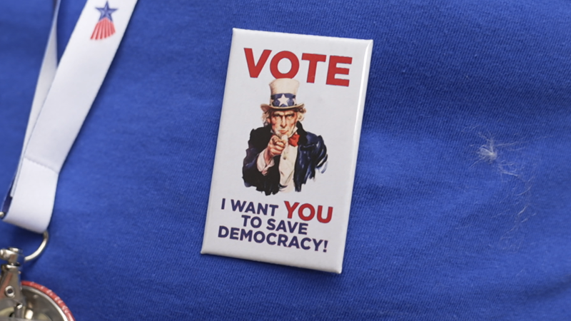 Zu sehen ist ein Sticker auf einem T-Shirt, der auf Englisch zur Wahl aufruft. | Bild: Bayerischer Rundfunk 2024 Zu sehen ist ein Sticker auf einem T-Shirt, der auf Englisch zur Wahl aufruft.