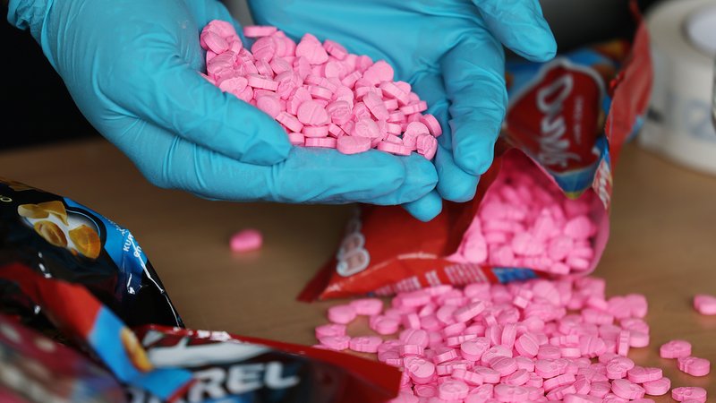 Hände in Gummihandschuhen halten sichergestellte Ecstasy-Tabletten in Totenkopf-Form | Bild: dpa-Bildfunk/Oliver Berg Hände in Gummihandschuhen halten sichergestellte Ecstasy-Tabletten in Totenkopf-Form
