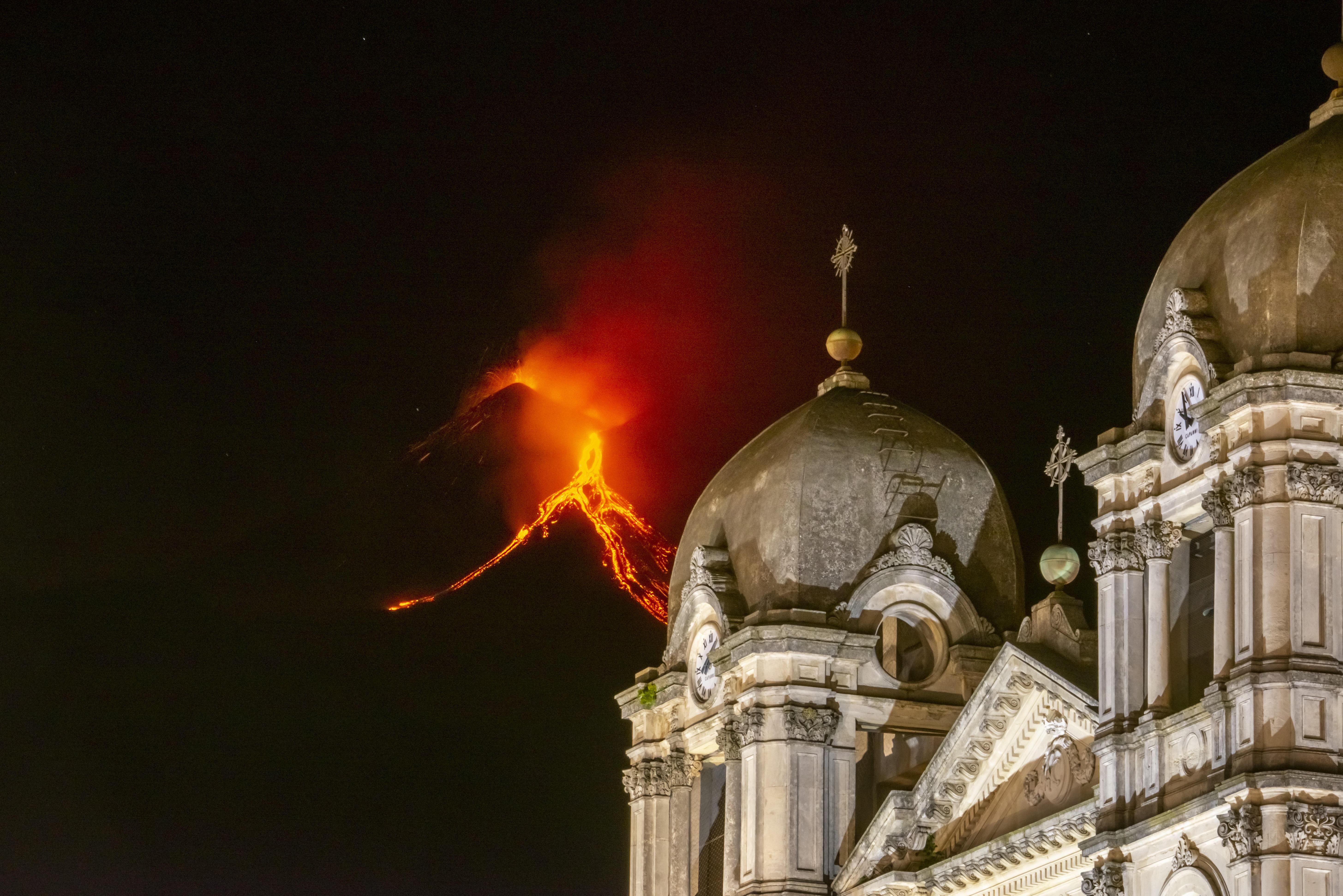Lava strömt den Ätna herab. Im Vordergrund die Kirche Santa Maria in der Gemeinde Zafferana Etnea.
