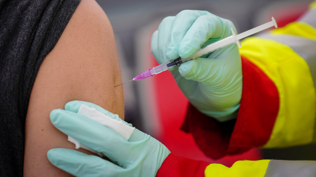Eine Ärztin setzt eine Spritze mit dem Impfstoff von Biontech bei einem Patienten.