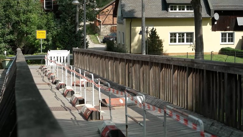 Eine Holzbrücke ist mit rot-weißen Absperrbändern gesperrt. | Bild: BR Eine Holzbrücke ist mit rot-weißen Absperrbändern gesperrt.
