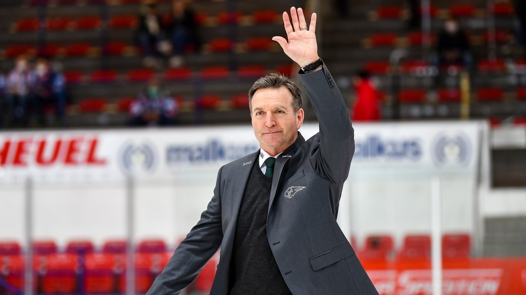 Serge Pelletier, Headcoach der Augsburger Panther, steht auf dem Eis und hebt die Hand
