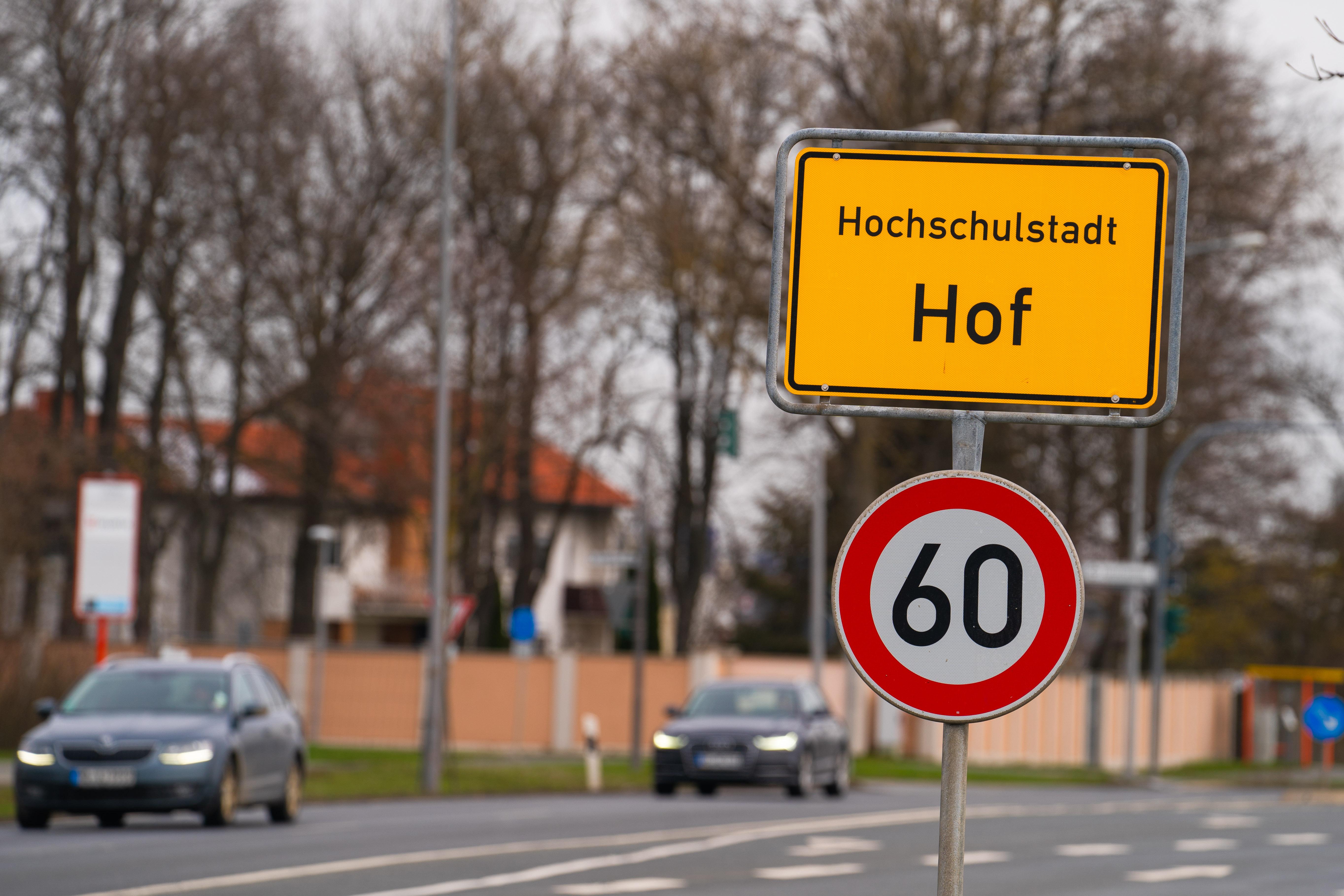 Autos fahren am Ortsschild der Stadt Hof vorbei. 