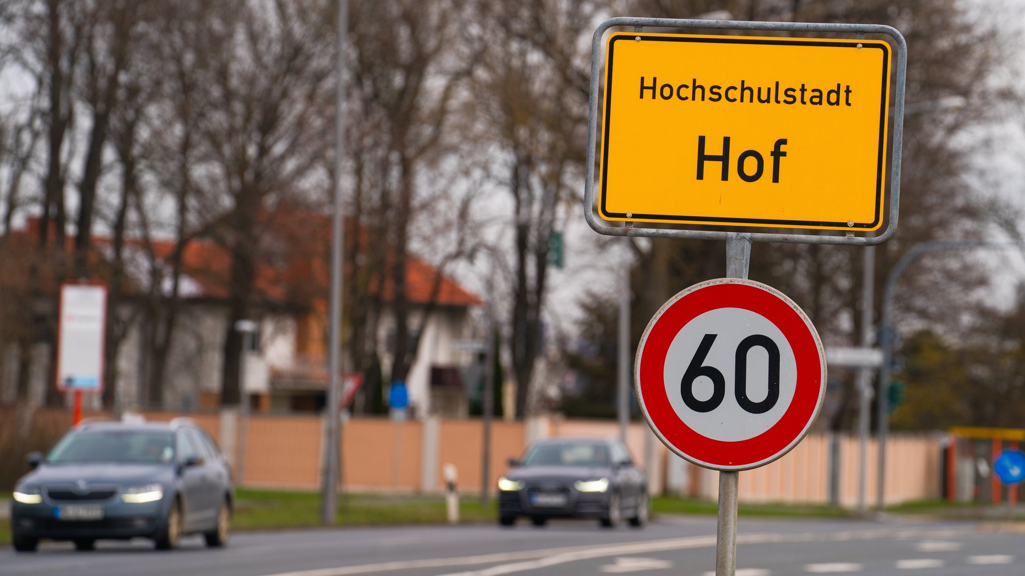 Autos fahren am Ortsschild der Stadt Hof vorbei. 