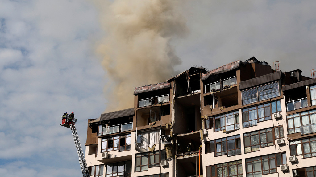 Feuerwehrleute löschen einen Brand in einem Wohnhaus in Kiew, das von einer russischen Rakete getroffen wurde