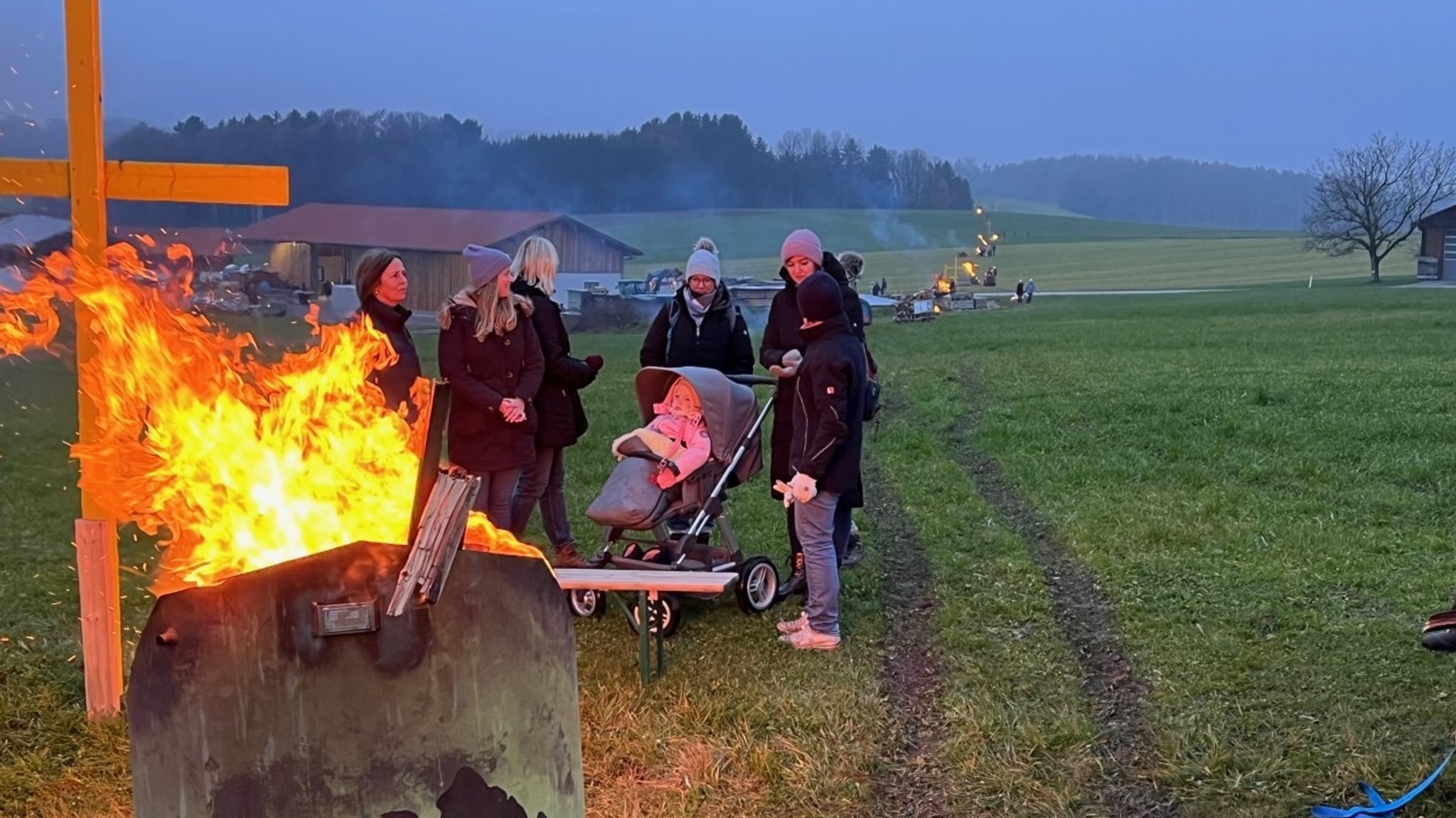 Familien stehen um ein Feuer