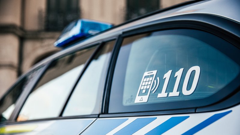 Die Notrufnummer "110" steht auf einem Polizeiauto.