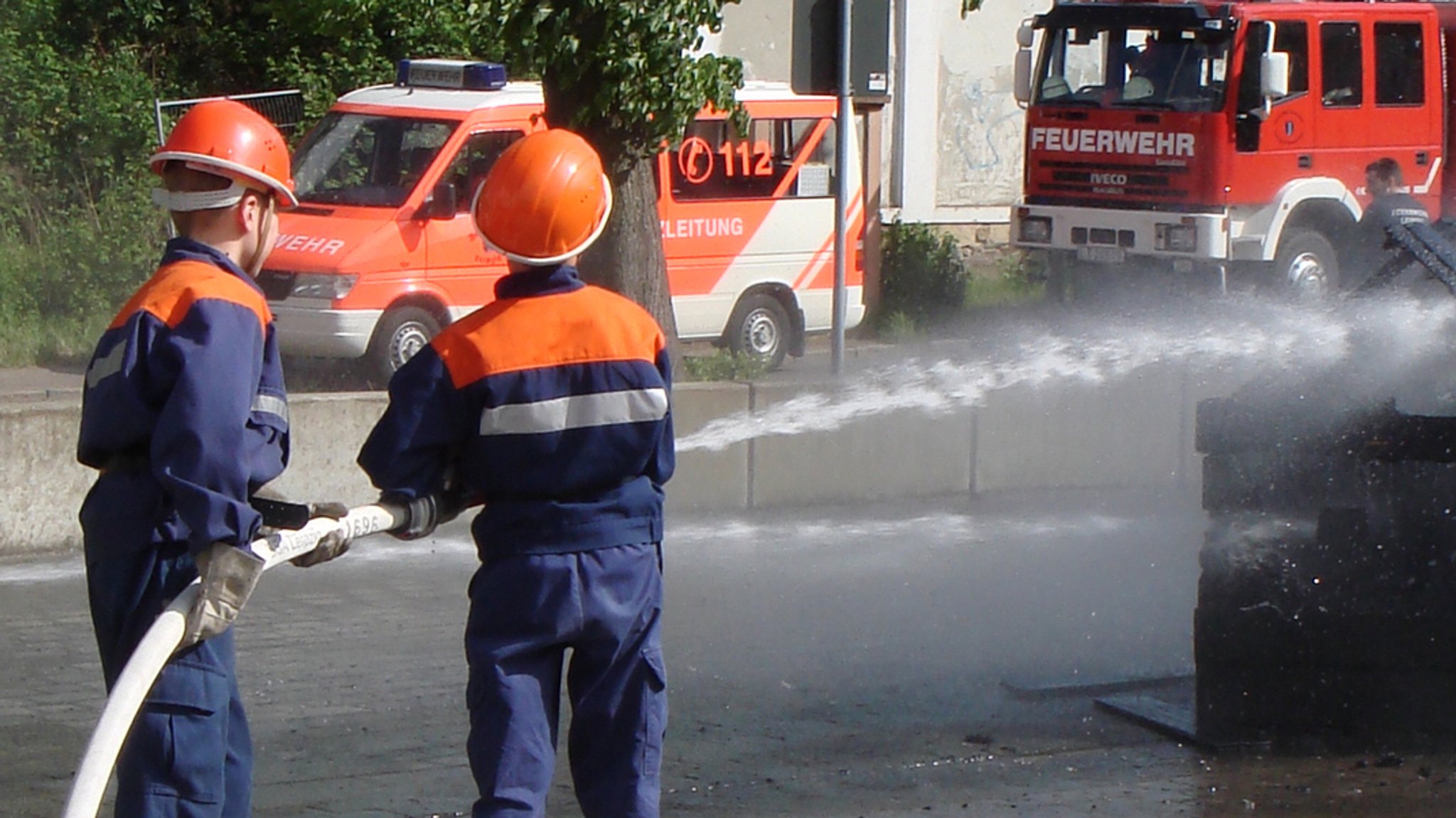 Zwei Kinder der Freiwilligen Feuerwehr halten einen Löschschlauch