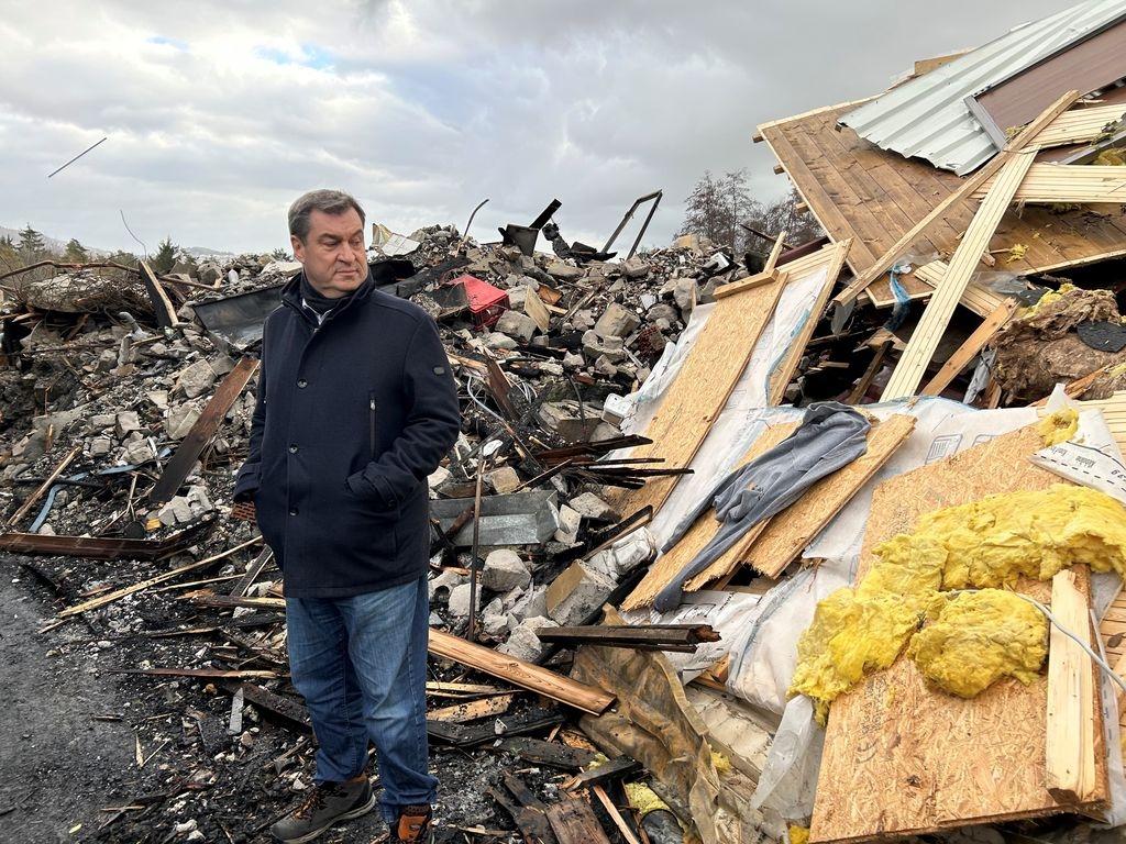 Ministerpräsident Söder neben den Schutthaufen in Pullman City.