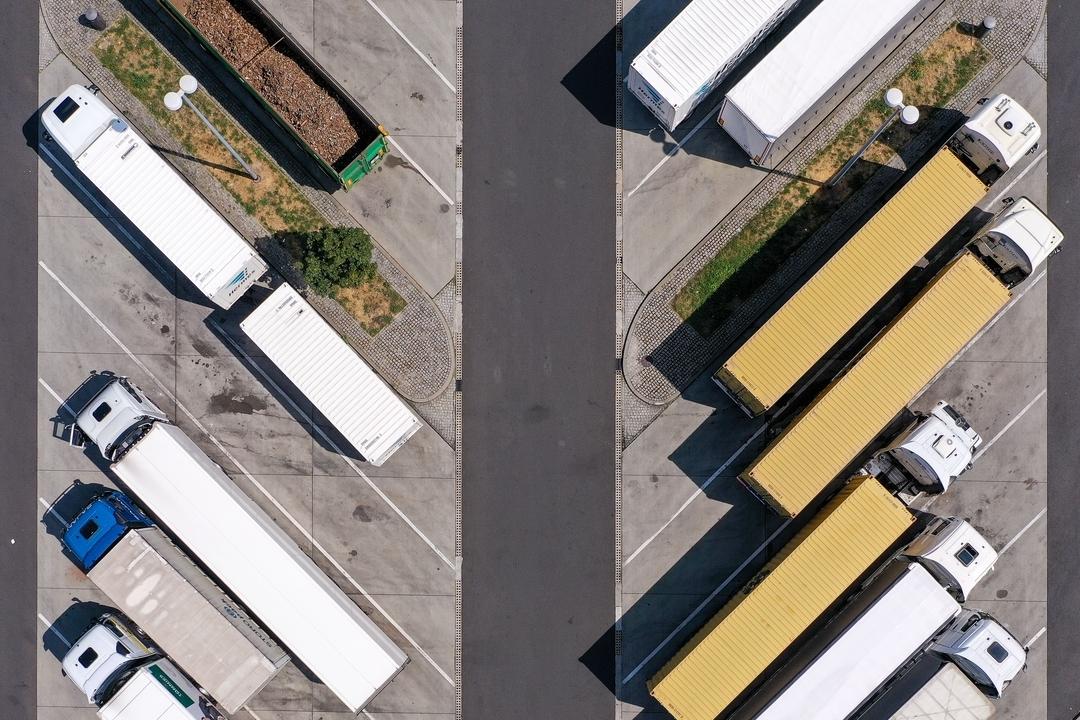 Mehrere geparkte LKWs an einer Raststätte