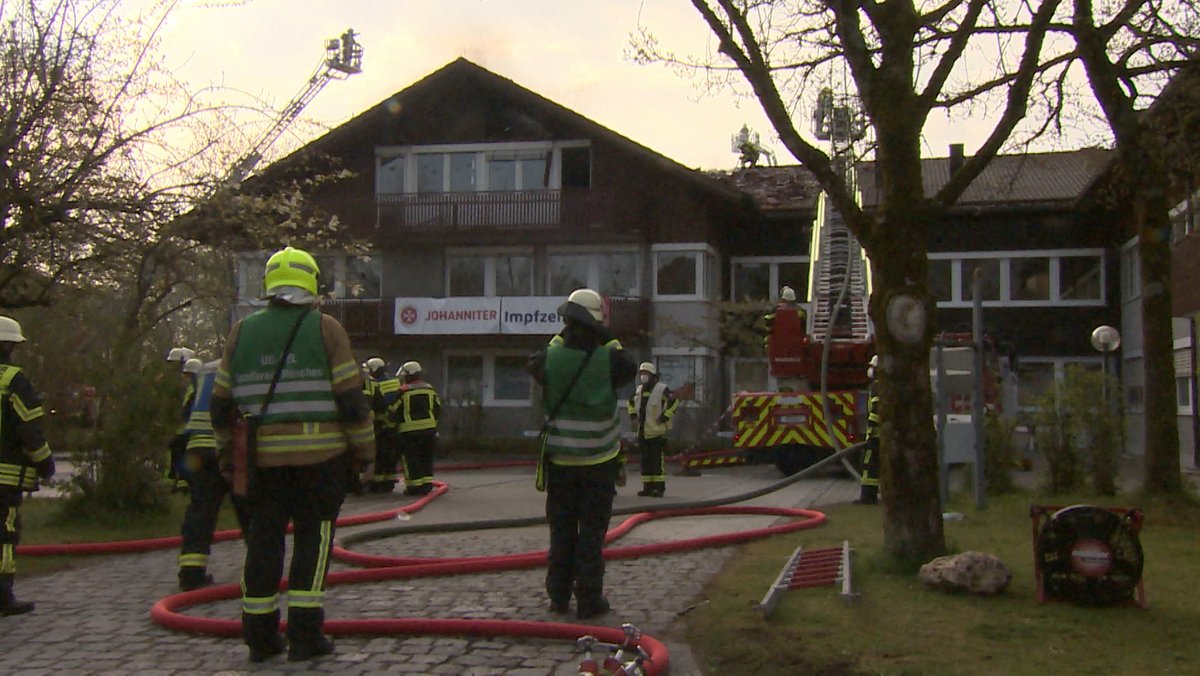 Feuerwehrmänner stehen vor Impfzentrum in Oberhaching
