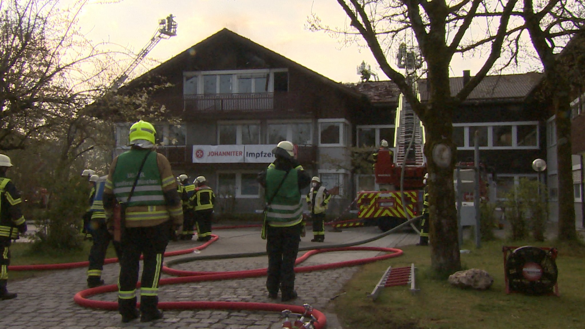 Feuerwehrmänner stehen vor Impfzentrum in Oberhaching