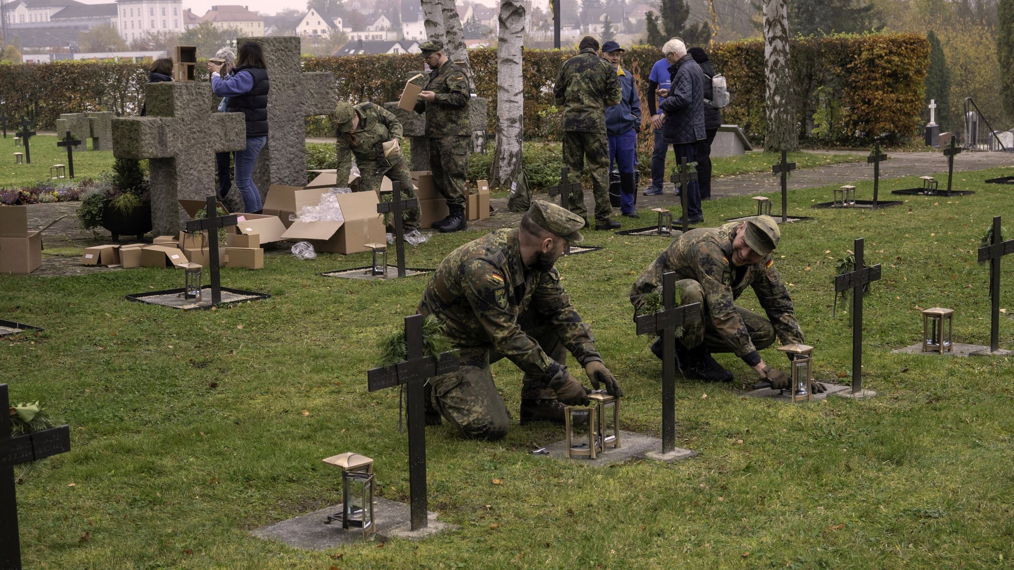 Soldaten montieren die neuen Grablaternen auf dem Soldatenfriedhof.